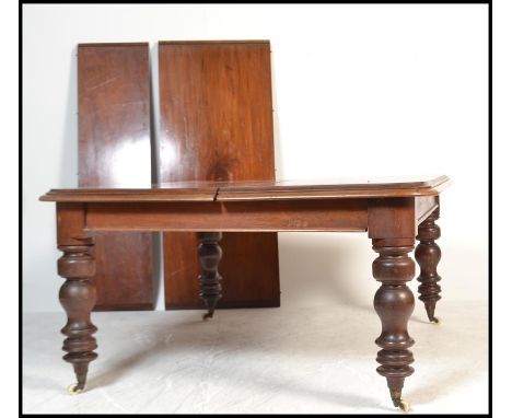 A large 19th century Victorian mahogany extending twin leaf dining table. The large, wide table top with turned legs and cast