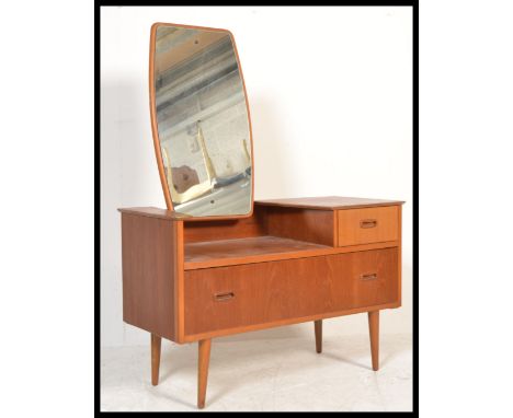 A 1970's retro Danish influence teak wood dressing table chests being raised on turned legs with two tone colour way to the d