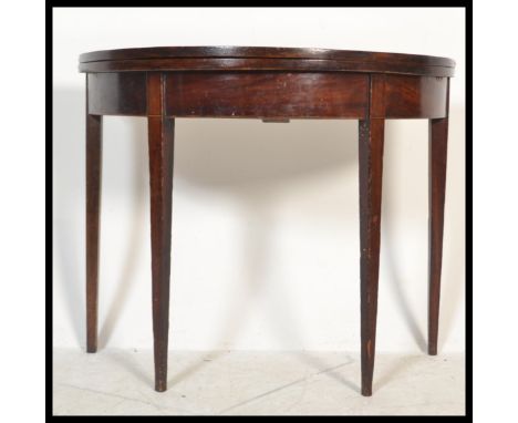 A 19th century George III mahogany demi lune tea table / games card table. Raised on square tapering legs , above a fitted fr