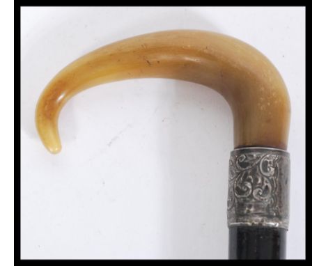 A 19th century silver hallmarked collared walking stick cane having a tapering ebony shaft with shaped horn handle. The silve