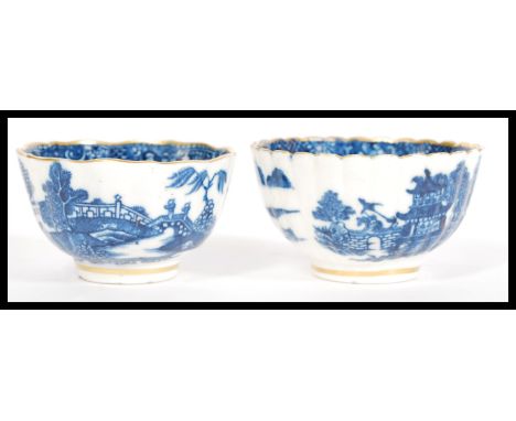 A pair of early 19th Century English porcelain tea bowls having blue and white decoration with gilt borders. In the manner of