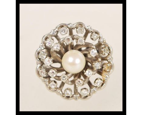 A 14ct white gold diamond and pearl cluster ring having a central pearl with two halos of diamonds. Size N weighs 7.8 grams.