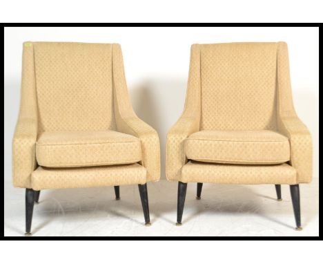 A pair of mid 20th century vintage / retro armchairs - wedge chairs being raised on turned ebonised and tapering supports wit