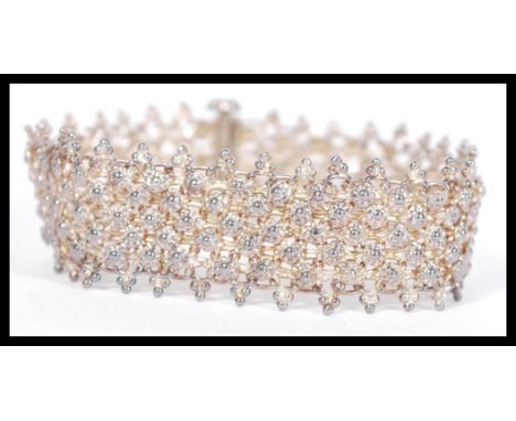 A vintage early 20th century Asiatic silver white metal mesh bracelet with floral head spacers and links. Weighs 22.1 grams.