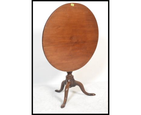 An 18th century solid mahogany tilt top wine / occasional table being raised on splayed tripod leg base with turned column an