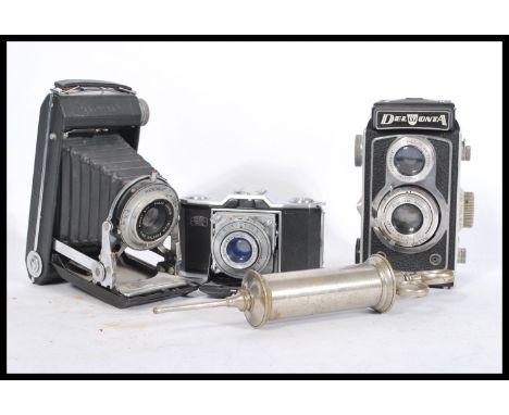A selection of three vintage cameras to include a Kodak Dakon Shutter bellows camera, a Zeiss Ikon film camera and a Delmonta