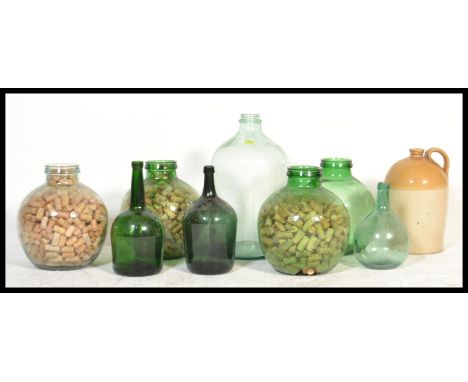 A collection of vintage 20th century acid glass carboys - bottles of large form some filled with wine corks together with lar