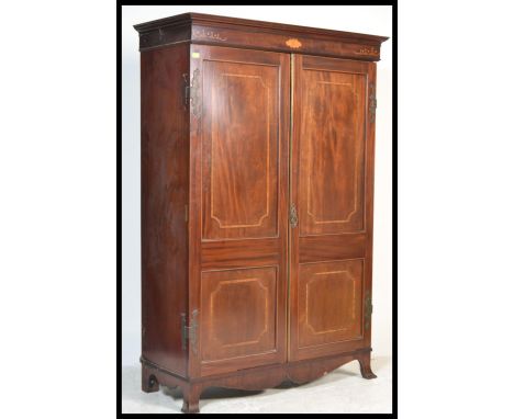 A 19th century mahogany inlaid double wardrobe being raised on French bracket kick feet with fielded panel full length double