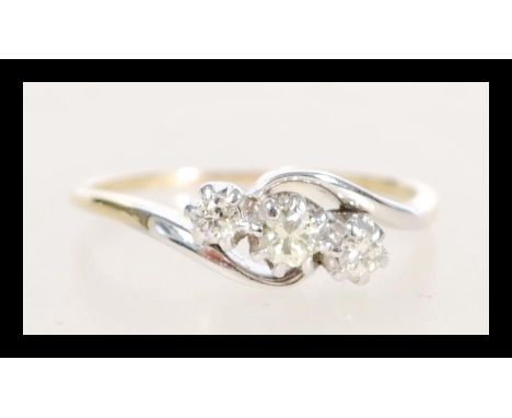 A stamped 14ct gold crossover ring prong set with three brilliant cut diamonds. Weight 2.7g. Size O.5. Approx 25pts.&nbsp;