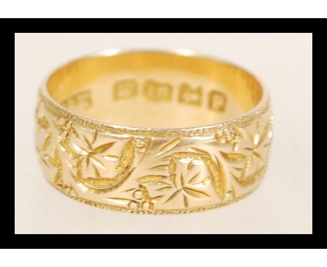 A 19th Century Victorian hallmarked 18ct gold band ring with floral engraving. Hallmarked Birmingham 1864. Weight 4.8g. Size 