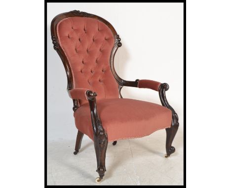 A Victorian 19th century mahogany armchair being raised on carved legs with ceramic castors having show wood rococo frame uph