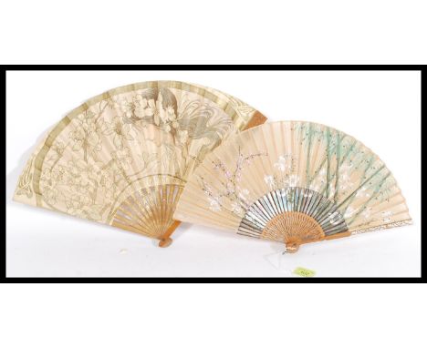 Two vintage early 20th century fine hand fans to include a French example with depicting a maiden with flowers retailed by Du