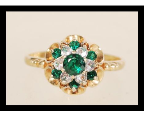 A hallmarked 9ct gold cluster ring set with green and white stones. Hallmarked Birmingham 1979. Weight 3.0g. Size P.