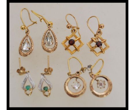 A group of 9ct gold earrings to include square white stone ring drops, green and white stone drops, square pair of faceted re