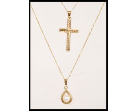 A stamped 375 pendant necklace having a teardrop pendant set with a pearl along with a stamped 375 9ct gold crucifix necklace