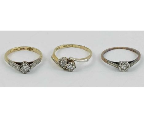 A two stone diamond cross over ring, stamped ‘18ct’ and ‘Fine Plat’, the brilliant cuts illusion set; and two other illusion 