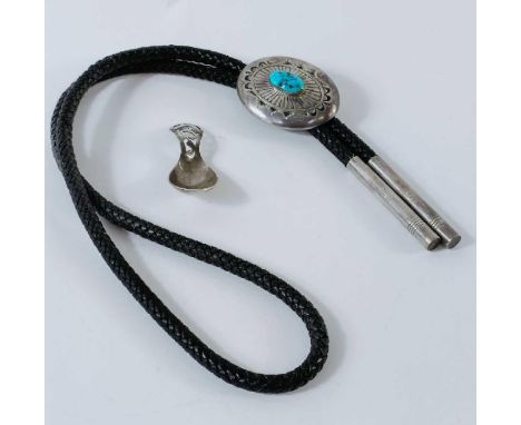 A Navajo turquoise set oval slide piece to a plaited leather neck tie with silver ends, stamped CJ and Sterling; with a silve