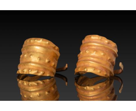 Ca. 1500 - 1200 BC. A matched pair of gold earrings formed from a thin sheet of metal and shaped into broad, semi-cylindrical