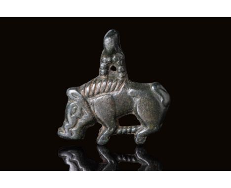 Ca. AD 950 - 1030. A cast bronze pendant in the form of a stylised wild boar, depicted with a broad body, short legs, a prono