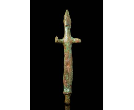 Ca. 2000 - 1700 BC. A bronze idol cast in abstract anthropomorphic form. The figure stands upright with an elongated body, sh