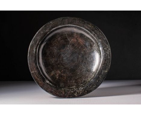 Ca. AD 500 - 600. A silver dish with a shallow bowl with a rounded base. The rim is broad and everted, enclosing a plain cent