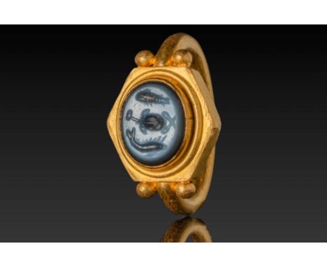 Ca. AD 500 - 700. A nicolo intaglio engraved with a central turtle flanked symmetrically by two fish. Set in a high-collared 