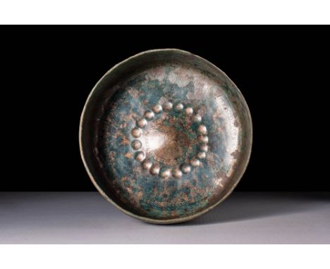 Ca. 600 - 750 BC. A deep cylindrical bronze bowl with a flat base. The interior is decorated with concentric bands of dotted 