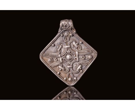 Ca. AD 800 - 1100. A silver medallion of lozenge form with a suspension loop at the top. The obverse is decorated with a cent