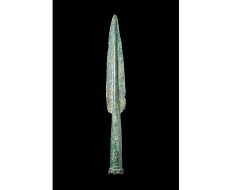 Ca. 1500 - 900 BC. A leaf-shaped bronze spearhead with a broad, symmetrical blade flaring gently from the tip. A pronounced c