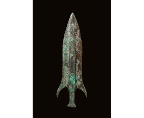 Ca. 1000 - 800 BC. A bronze spearhead with a leaf-shaped blade and prominent central rib. The shoulders flare into lateral ba