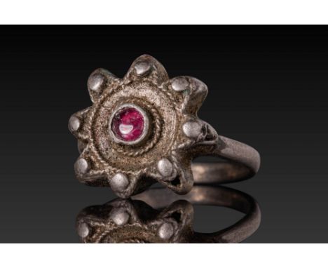 Ca. AD 300 - 500. A silver ring with a prominent bezel in the form of an eight-lobed rosette, each lobe terminating in a rais