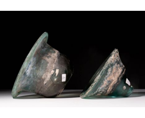 Ca. AD 600 - 800.A pair of deep green glass oil lamps, one with a rounded body and the other with a conical form, both with d