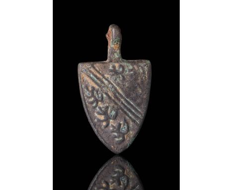 Ca. AD 1250 - 1325 . A shield-shaped bronze horse harness pendant with a suspension loop at the top. The front is decorated w