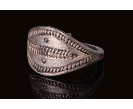 Ca. AD 900 - 1000. A silver ring with an expanded bezel decorated with two horizontal bands across the centre, enclosed by a 