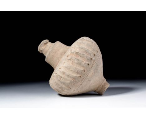 Ca. AD 900 - 1102. A terracotta grenade of a compact form with a wide upper curve and a tapering base. The central section is