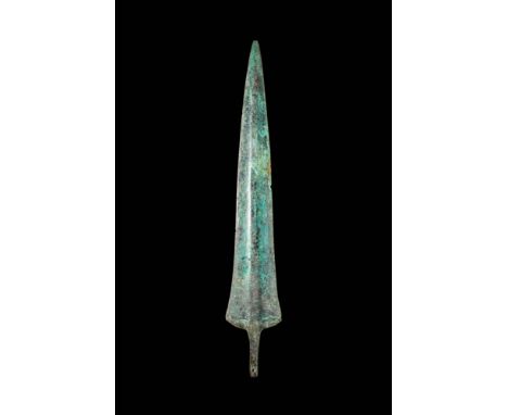 Ca. 1200 - 800 BC. A bronze spearhead with a long, tapering blade with a raised rib that runs its full length. The blade expa