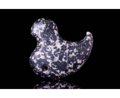 Ca. 3500 - 3000 BC. A Mesopotamian finely carved from a dense, black and white speckled stone, this amulet takes the stylised