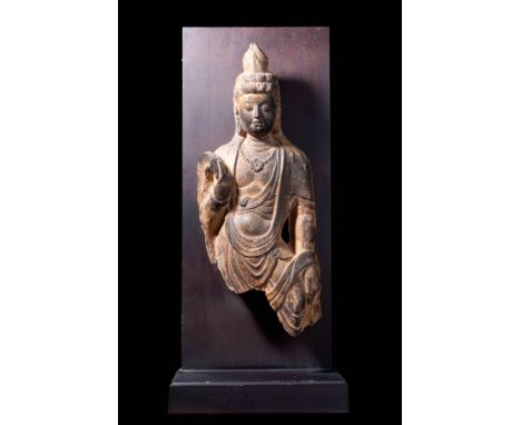 Ca. AD 618-907. A stone figure of Guanyin. Dressed with a finely detailed necklace, flowing robes, and a high chignon secured