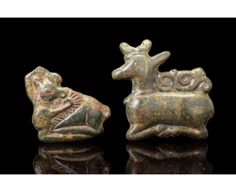 Ca. 500 - 300 BC.A pair of bronze appliqués depicting recumbent horned animals, each with a rectangular hollow mount on the r