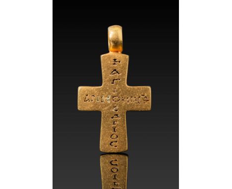 Ca. AD 800 - 900.A solid gold cross pendant with broad arms engraved with a Greek inscription running vertically and horizont