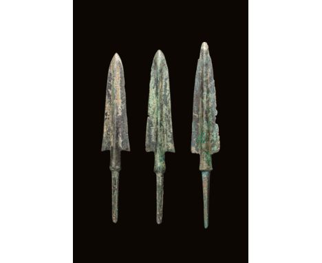 Ca. 1000 - 800 BC. A collection of three bronze arrowheads, each with an elongated, triangular-shaped blade featuring promine