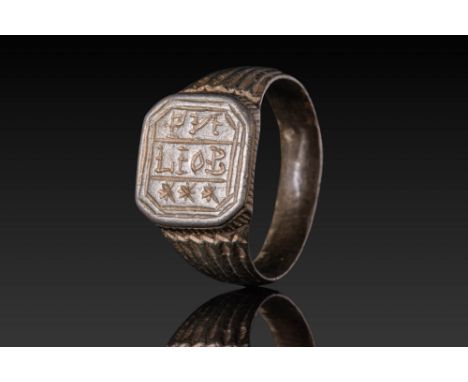 Ca. AD 1300 - 1500. A silver ring with an octagonal bezel engraved with an inscription surmounted by decorative stars. The sh