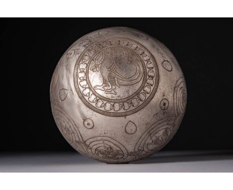 Ca. AD 400 - 600 BC.A hemispherical silver bowl engraved on the exterior with a continuous frieze of scrolling tendrils termi