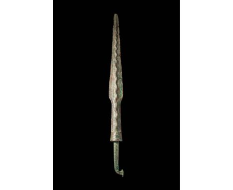 Ca. 1200 - 800 BC. A bronze spearhead with a narrow tapering blade that terminates in a sharp point. The central ridge is for
