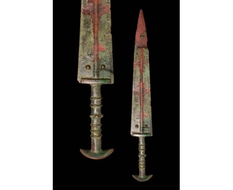 Ca. 1000 - 800 BC. A cast bronze sword with a flat, triangular blade and defined midrib. The cylindrical hilt includes a cres