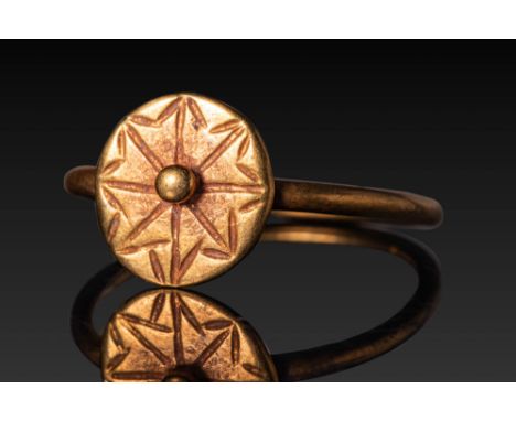 Ca. AD 600. A gold ring with a rounded bezel engraved with an eight-pointed star formed by intersecting linear motifs, each t