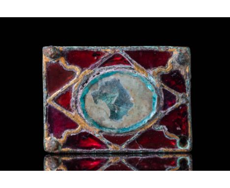 Ca. AD 400 - 600. A bronze belt fitting of a rectangular form with four corner rivets. The front is decorated with garnet inl