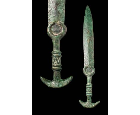 Ca. 1200 - 800 BC. A short bronze sword with a broad, slightly tapering blade. The hilt consists of a guard with projecting c