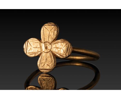 Ca. AD 800 - 1000. A gold ring with a cross-shaped bezel formed of four rounded lobes, each incised with linear and hatched d