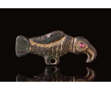 Ca. AD 500 - 700. A gilt-bronze brooch in the form of a stylised bird with a short tail and curved beak. The body is decorate